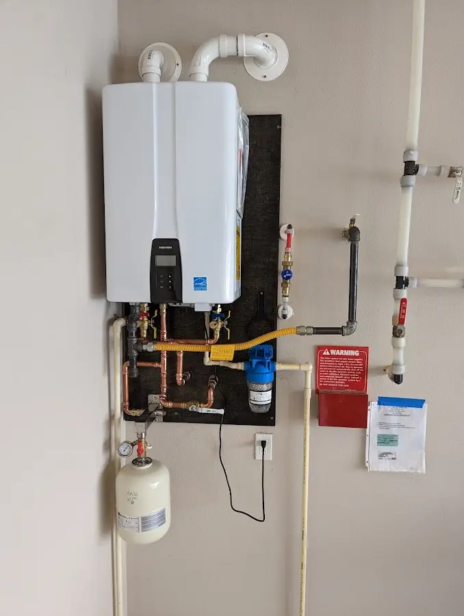 Professional plumber installing copper piping in a Pittsboro home